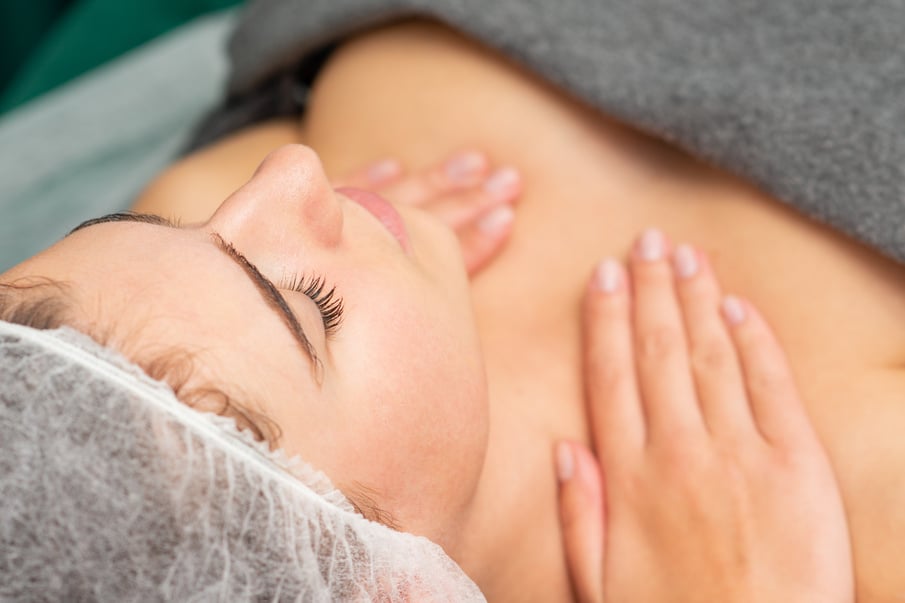 Massaging Female Chest. Young Beautiful Caucasian Woman with Closed Eyes Getting Chest Massage at Beauty Spa Salon.